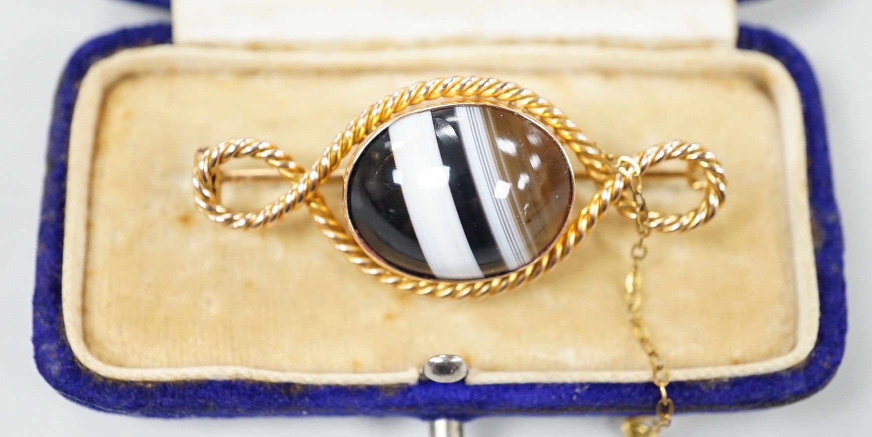 An Edwardian 15ct and banded agate set brooch, with rope twist border, 46mm, gross weight 8.2 grams.
